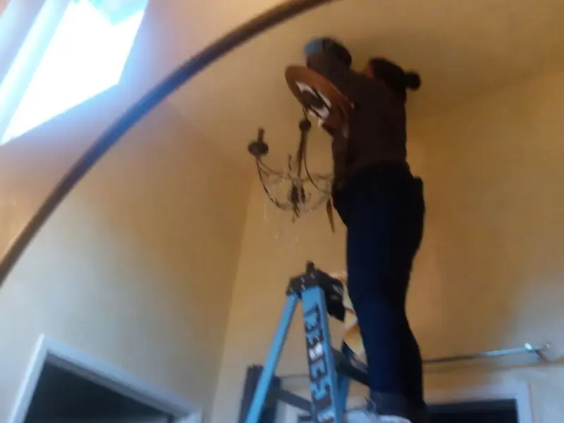 Electrician installing a chandelier in a Streamwood residence